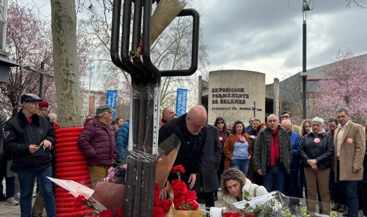 Unai Sordo deposita ur ramo de rosas rojas ante la escultura que homenajea a los trabajadores asesinados en 1976, en la plaza Tres de Marzo, en el barrio de Zaramaga. de Vitoria.