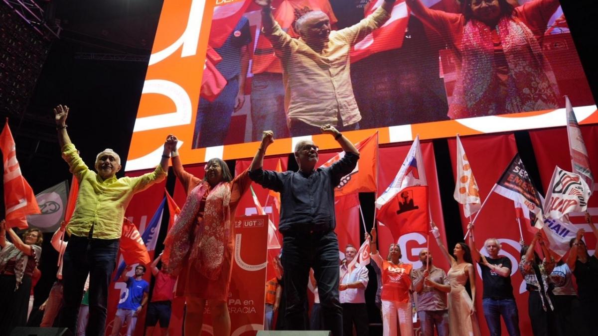 Unai Sordo, secretario general de CCOO, rodeado por todas las siglas, todas las banderas de las organizaciones sindicales congregadas en el Palaico de Vistalegre de Madrid.